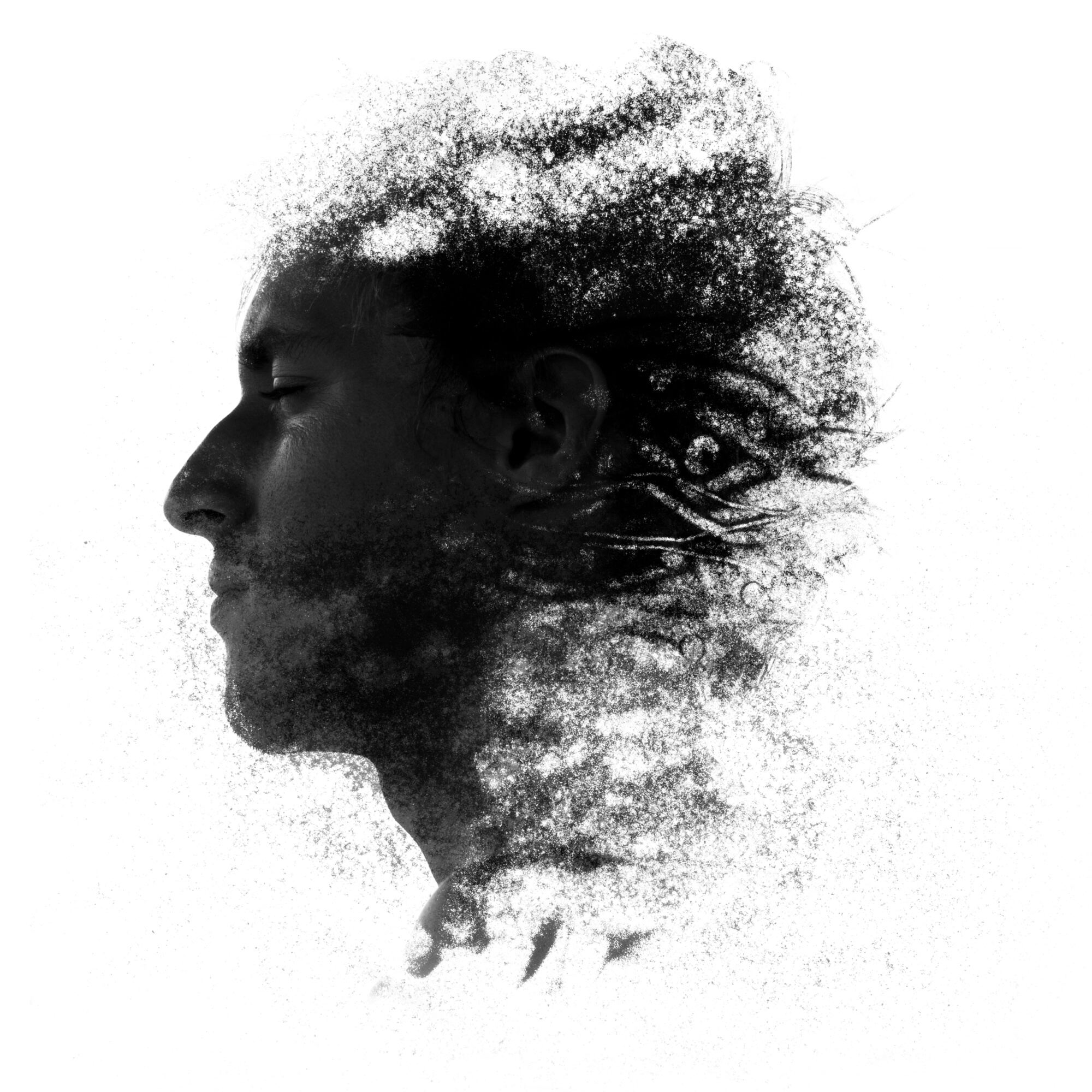 Abstract portrait of a man's face dissolving into particles